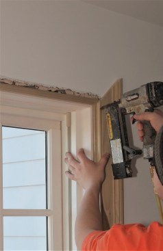 Finish nails tack the first side casing in place. Nails are driven into parts of the profile that will be easy to fill before painting. 