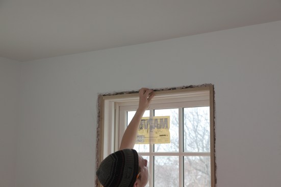 The extension jamb for the top of the window fit between the side extensions. The crew installed the extension jamb strips with a 1/4-inch reveal from the edges of the factory jambs.