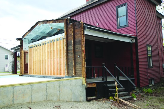 After gutting the home’s one-story connector and sealing the framing with primer, the crew poured a new garage foundation.