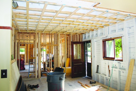 The existing ceiling and hardwood floors were removed in the connector’s kitchen area. Wall, ceiling, and roof framing was primed and left “open” for three months to air out.