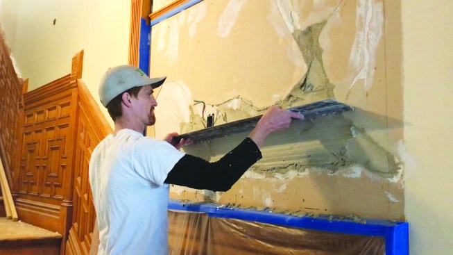 On large repairs, a 42-inch-long slicker is used to flatten the brown coat using a sawing motion.