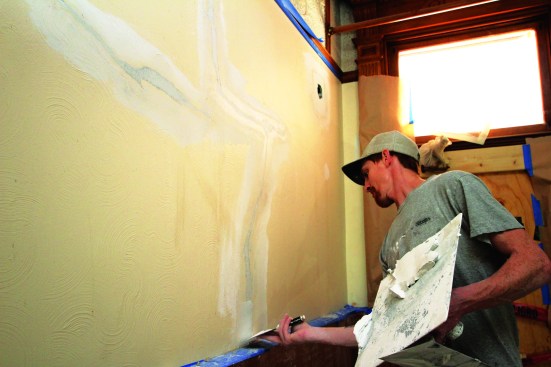 The lime-putty coat is applied in two passes; here, the first pass is made.