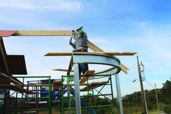 Like framing a hip roof, framing a cone (or in this case a half cone) begins with three common rafters. The first common rafter attaches to the end of the ridge.