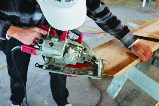 After measuring and marking the shoulders of the plumb cut, the crew member takes the saw angle from the floor drawing and cuts the top.