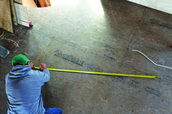 A full-scale plan drawing allows the crew to visualize the how the radial rafters intersect at the peak. A semicircle is swung to represent the top plate.