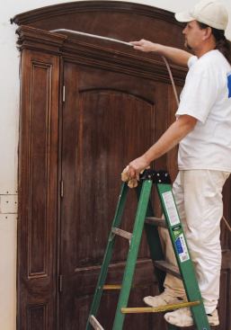 Compressed air is handy for removing sanding dust from cracks, but the trim must also be wiped down with a rag dipped in mineral spirits.