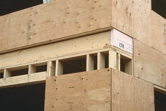 Recessing the band joist 2 inches provides room for exterior rigid foam insulation. To provide an air barrier, the foam is carefully caulked in place with Tremco acoustical sealant.