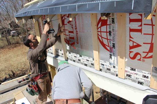 A look at the mostly furred-out wall shows the key durability details of the rain screen system: the foil drainage plane sealed with tape, the furring which creates an air space for drainage and ventilation, and the flashing and bug barrier at the bottom which will allow inflow of air into the cavity, equalizing air pressure across the siding and permitting incidental water to drain out of the assembly.