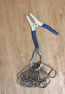 In the past I used extra nails to hold miters closed while the glue set. Now I use these small but powerful miter clamps. They aid in preassembly and eliminate the need for extra face nails – which is a plus when you’re doing high-end work. You use the spreader tool to get the clamps open and then release them on to the outside of the mitered pieces. They are very stiff (that’s why they clamp so well) so be careful not to get your finger caught between the jaws.