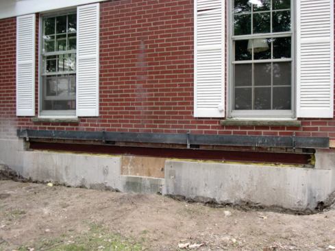 After slipping the I-beam into its slightly oversized pocket, the author shimmed it tight to the floor framing above.