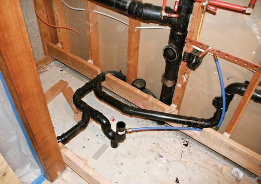 A new floor framed over the existing slab provides room for drain pipes and a trap primer.