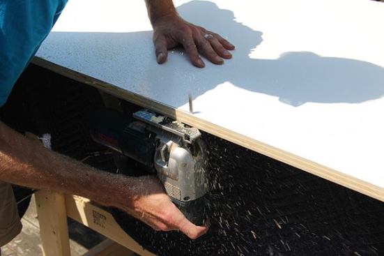 After making a preliminary cut close to the scribe line using a tracksaw, Jeff trims to the line using a jigsaw.