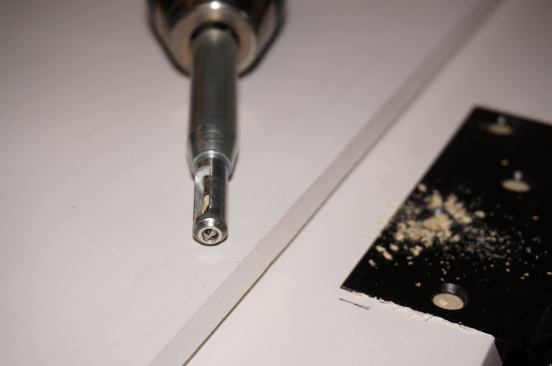A spring-loaded, self-centering Vix bit has a tapered guide that fits into the countersunk screw holes on the hinges.