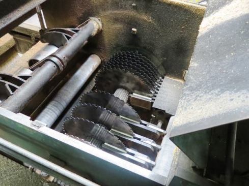 This is the inside of an edger; the blades can be positioned anywhere along the splined drive shaft and can be adjusted on the fly through the use of hydraulic cylinders. The closely spaced blades on the right side of the shaft are fixed, and are set up to rip 2-by out of a thicker piece. The blades on the left are the ones the operator is adjusting in the previous photo and video.