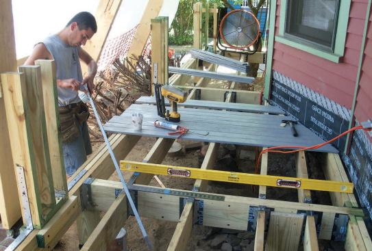 Short sections of knee wall were attached to the front of the deck with metal straps and framing anchors; later they would be enclosed by finished PVC pillars.