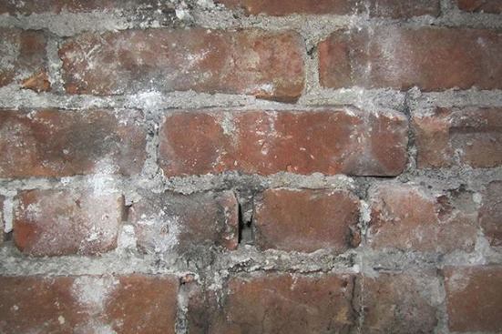 Before: the existing brick party walls are more than 100 years old. They need to be repointed and patched in places, then given a parge of lime-based mortar that matches the existing historic material.