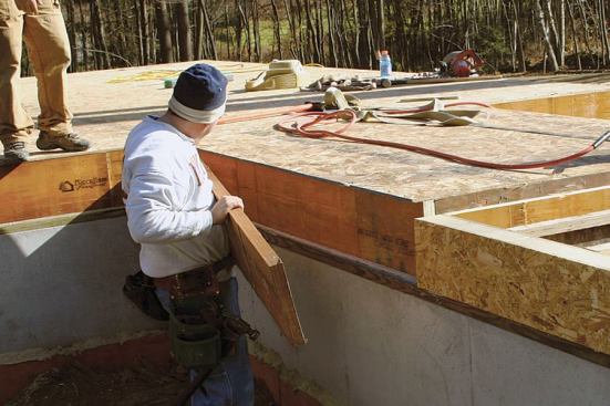 At the perimeter, carpenters install full-height LVL rim joists, using 2.5-inch pneumatic nails. The LVL perimeter members are overkill in structural terms, but sawn lumber would shrink away from the panels and compromise the integrity of the joints.
