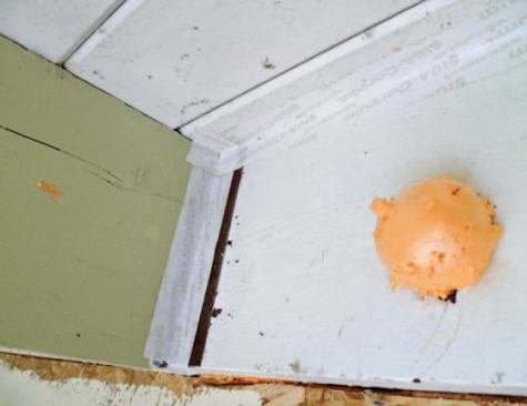 The excess foam that marks an injection hole for dense-pack cellulose will be trimmed off, and the tape covered with a plywood trim piece.