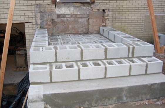 Each step is basically a platform built with 8-inch by 12-inch by 16-inch concrete masonry units (CMUs), stepped back far enough from the platform below it to allow room for a 12-inch-wide by 2-inch-thick limestone tread.