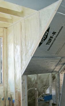 Note the insulated rim joist and squash blocks below the single top plate. A layer of 2-inch R-13 foam board completes the sloped ceiling insulation, yielding a total approximate R-value of 70.