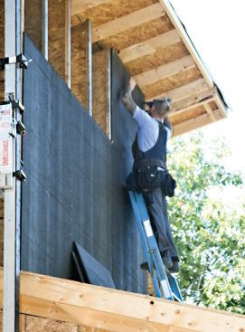 A secondary asphalt-faced fiberboard sheathing was installed over the wood I-joists to retain the cellulose insulation.