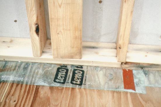 After the walls are raised, the transparent Tenoarm polyethylene sticks out from under the bottom plate, facing the interior. This flap will later be taped to the wall poly.