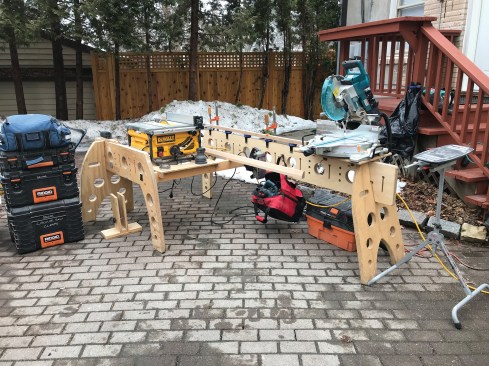 This configuration allows one carpenter to work efficiently, providing access to the miter saw and table saw from the same position. 