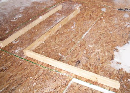 Wall Layout: We used a factory corner of a sheet of OSB as a giant framing square as we built the walls. I took the dormer's rise and run from the plans, and we cut the top plates and end studs accordingly.