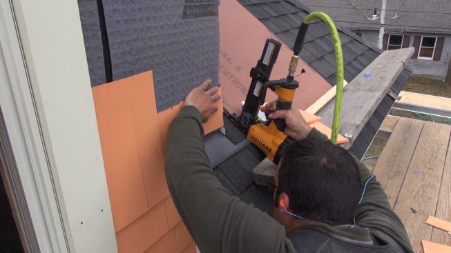 Pollard tacks up pieces of the thin ends of shingles for triple coverage above the roof.