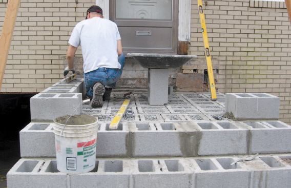 As we set the blocks for each platform, we mortared the joints around the perimeter, then infilled with more blocks set in mortar. There’s no vertical reinforcement, but we filled the perimeter cores with mortar and the interior cores with 3/4-inch stone.