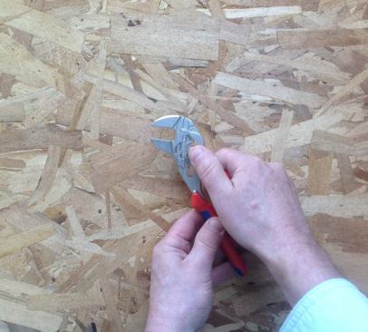 The jaws are adjusted by pressing a spring-loaded button and sliding the pivot point up or down.