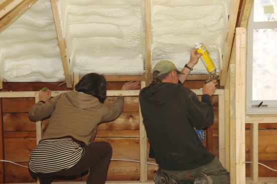 Rachel Conly and Ed Muennich find and seal air leaks.