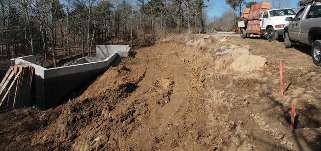 A section of the lot between the foundation and the street above was then backfilled to provide the required level base for the septic system.