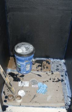 I used mastic to adhere the Durock to the studs, making sure that the lowest nails in the cement board were no lower than the top inch of the membrane underneath.