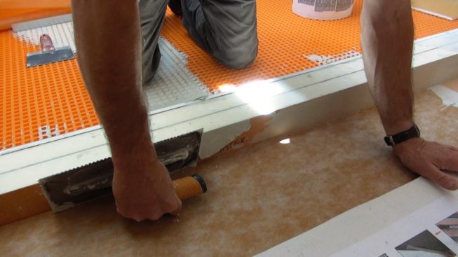 Boucher applies mortar to the inside face of the curb. As in every situation, the first step is to work the mortar thoroughly into the surface that's being prepared, to ensure a good bond.