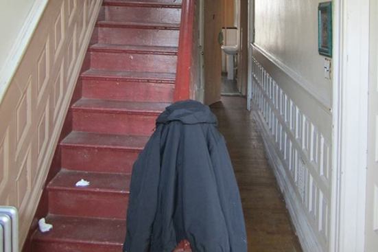 Built in the late 1800s, the house has a staircase hugging the left side of the house, running along a party wall shared with the neighboring building. The wall to the right of the long hallway serves as a “load-relieving wall,” breaking up the span of joists that run across the width of the long, narrow home (the crosswise joists bear at either end on the structural brick party walls that divide the units). When this bearing wall is removed during the remodel, the existing floor joists will need to be reinforced.