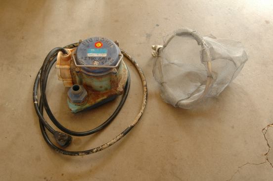 This small, reliable sump pump has a pressure-activated internal switch and can move more than 2,500 gallons of water per hour. The filter enclosure it fits in was cobbled together with some window screen attached to a loop of Romex.