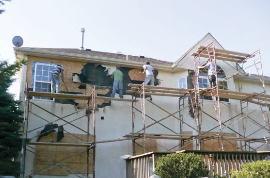 Repairs to leaking windows required removal of this house's exterior stucco.