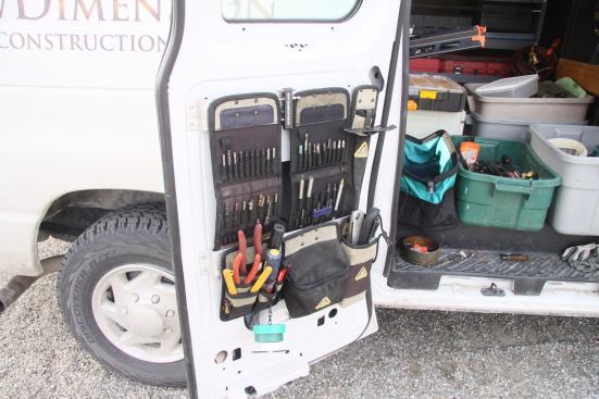 Customized aluminum brackets mounted to the inside of the van door hold more Iron Dog accessories. Having pencils and bits in full view and easily accessible is appreciated by all on the crew.