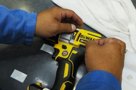Having passed its performance test this hammer drill driver is having labels applied. At first I was amazed by how many labels go onto each tool. But then I remembered doing 
a teardown of a DeWalt impact driver and how many labels I had to slit to get the case to come apart. Interestingly, DeWalt uses a jig equipped with laser beams to check the labels on each tool and make sure all of them are in place.