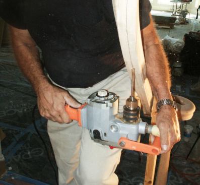 The tops of the iron balusters fit into 1-inch-deep holes drilled in the handrail and are held in place with clear adhesive caulk. The shallower curb holes are filled with epoxy as the balusters are installed.