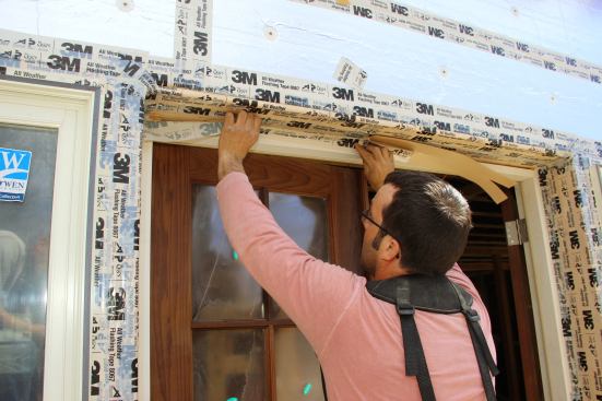 Project manager Mark Pollard seals a gap around a door jamb with 3M 8067 sealant tape.