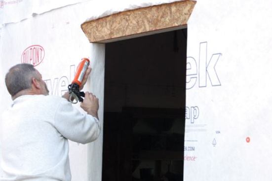 Caulk the Opening
Before installing the window, I apply a heavy bead of elastomeric latex caulk at the jambs and the head, but I never caulk the sill flange area. 
Note: Should any moisture find its way into the rough opening, this caulk-free sill flange, coupled with the sloped sill, will provide a weep area for water to escape.