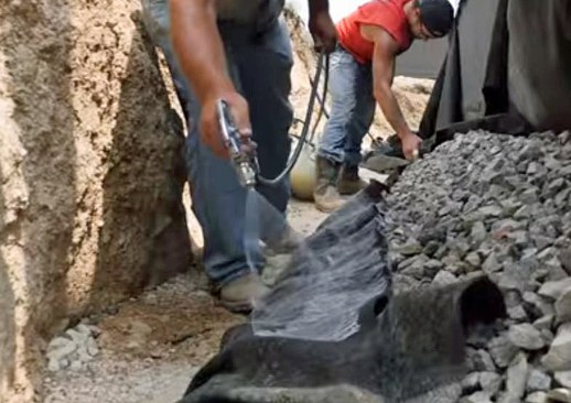 Spray adhesive is applied along one edge of the filter fabric.