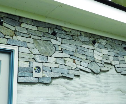 One additional important detail to keep in mind when using a drainage plane is to provide a means for the water to get out at the bottom and for air to get in from the top. At the top and the bottom, we installed a Delta-Dry insect screen, hidden at the top by a small fascia board and simply compressed at the bottom. We also incorporated some weep holes at the bottom that were hidden between the joints.