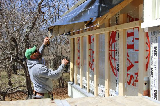 Fenton snaps a line on the fascia cut of the existing roof rafters. Irregularities in the existing house framing made it hard to establish straight, level lines around the roof on the remodeled eave.