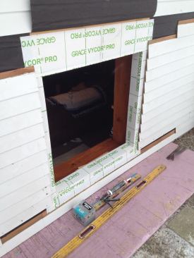 The opening is built out, taped and ready for the new window. Careful preparation meant that the inside of the house would be exposed to the elements for a minimal amount of time. Note that the existing underlayment over the window has been tacked up and out of the way.