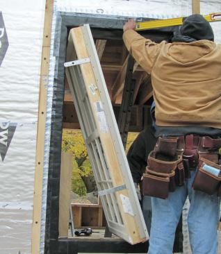 Metal strap ties screwed to the jambs secure the windows to the framing.