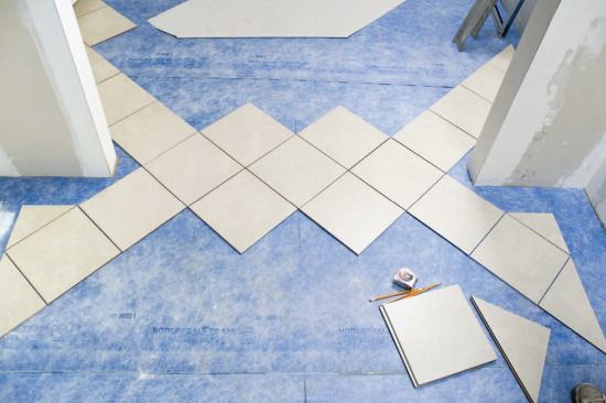 Once the membrane has been installed with Noble's contact-type adhesive, tile layout and installation should follow as soon as possible to lessen the risk that the membrane surface will get dirty or damaged.