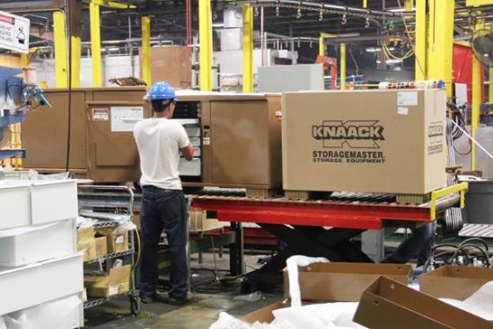 In the final assembly area for Knaack products a worker installs drawers in a Storagemaster rolling work bench.